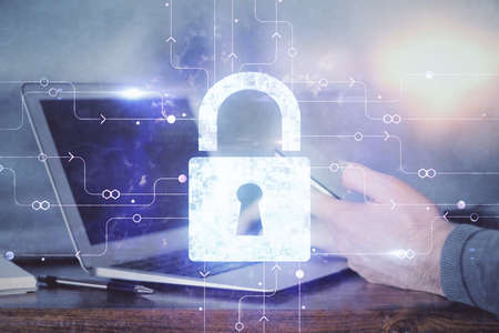 Multi exposure of man's hands holding and using a digital device and lock drawing. Security concept.の写真素材
