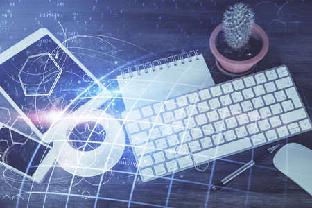 Double exposure of map hologram drawing over desktop. Top view. International connection concept.