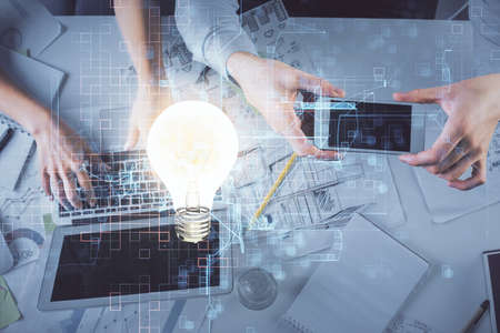 Double exposure of man and woman working together and bulb drawing. Computer background. Top View. Idea concept.の写真素材