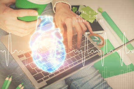 Double exposure of woman hands typing on computer and heart hologram drawing. Education concept.
