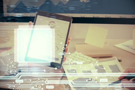 Double exposure of man's hand holding and using a digital device and data theme hologram drawing. Technology concept.の写真素材