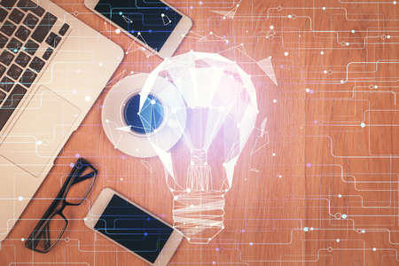 Double exposure of bulb drawing over table with phone. Top view. Concept of idea.の写真素材