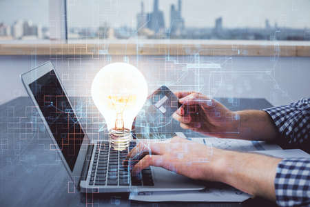Double exposure of man hands holding a credit card and bulb drawing. Idea E-commerce concept.の写真素材