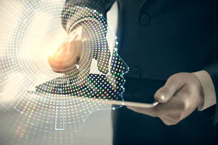Double exposure of man's hand holding and using a digital device and brain hologram drawing. Data...