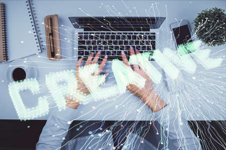 Double exposure of woman hands working on computer and creative hologram drawing. Top View. Start up concept.の写真素材