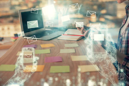 Double exposure of woman hands typing on computer and flying envelop drawing. E-Mail concept.