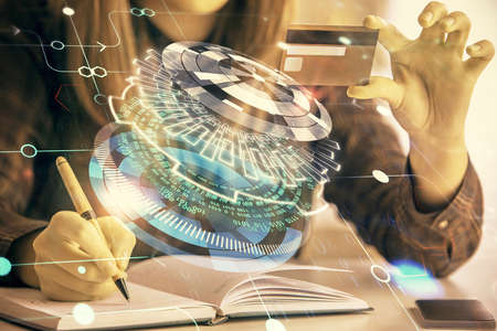 Double exposure of woman on-line shopping holding a credit card and data theme hologram drawing. E-commerce concept.の写真素材
