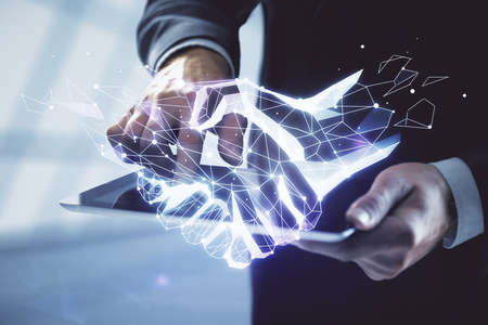 Double exposure of man's hands holding and using a digital device and handshake drawing. Partnership...