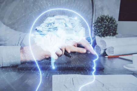 Double exposure of man's hand holding and using a digital device and brain hologram drawing. Data...
