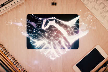 Multi exposure of handshake drawing over table with phone. Top view. Concept of partnership.の写真素材