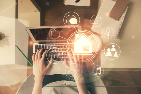 Double exposure of woman hands working on computer and buildings construction hologram drawing. Top View. smart city concept.の写真素材
