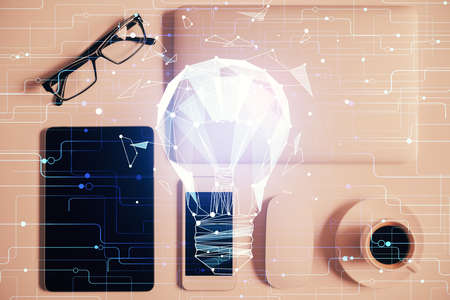 Double exposure of bulb drawing over table with phone. Top view. Concept of idea.の写真素材