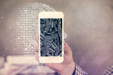 Double exposure of man's hand holding and using a digital device and brain hologram drawing. Data...