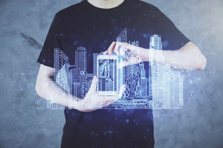 Double exposure of man's hands holding and using a digital device and city drawing.の写真素材