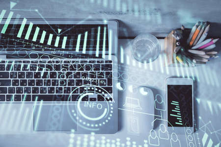 Technology hologram drawing over computer on the desktop background. Top view. Double exposure. Tech...