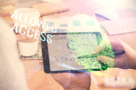 Double exposure of man's hands holding and using a digital device and fingerprint hologram drawing....