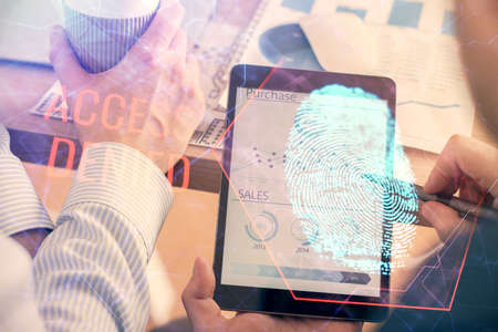Double exposure of man's hands holding and using a digital device and fingerprint hologram drawing....
