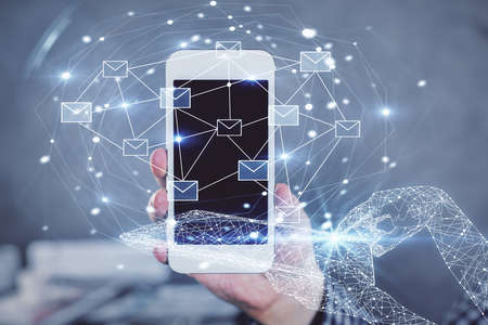 Double exposure of man's hands holding and using a digital device and envelop hologram drawing....