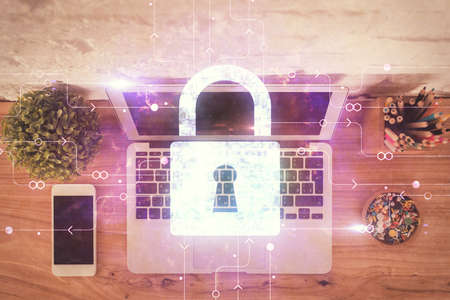 Double exposure of lock hologram drawing over study table background with computer. Concept of data...