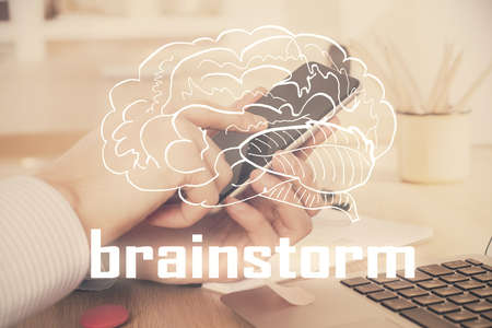 Double exposure of man's hands holding and using a mobile device and creative hologram drawing.の写真素材