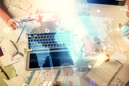 Double exposure of man and woman working together and technology theme world map drawing hologram....