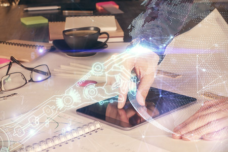 Double exposure of man's hands holding and using a digital device and tech theme hologram drawing. Technology concept.の写真素材