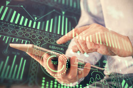Double exposure of man's hands holding and using a digital device and tech theme hologram drawing....