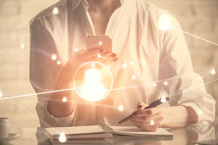 Double exposure of social network sketch hologram and woman holding and using a mobile device.の写真素材