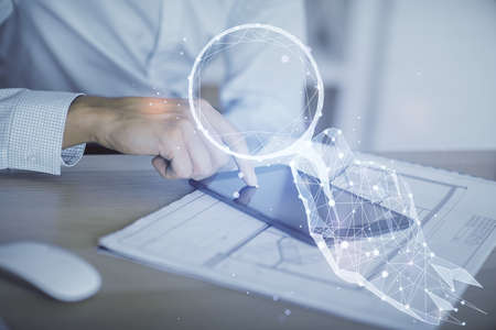 Double exposure of man's hands holding and using a mobile device and creative hologram drawing.