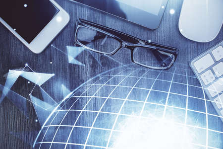Double exposure of map hologram drawing over desktop. Top view. International connection concept.の写真素材