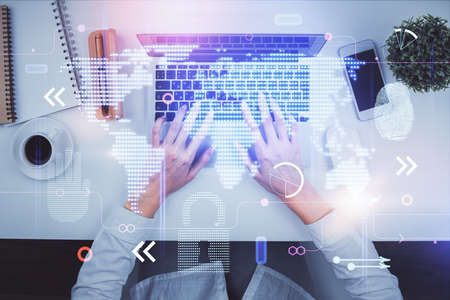 Double exposure of woman hands working on computer and world map hologram drawing. Top View....