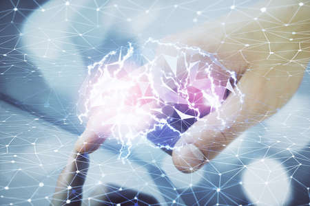 Double exposure of man's hand holding and using a digital device and brain hologram drawing. Data...