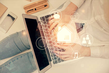 Double exposure of woman hands working on computer and buildings construction hologram drawing. Top View. smart city concept.の写真素材