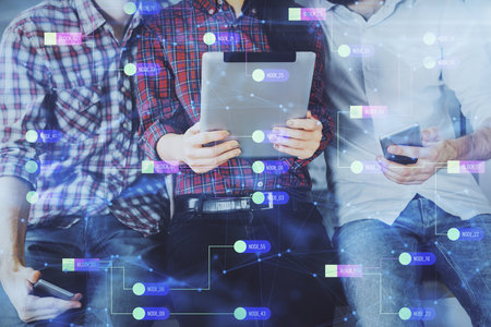 Double exposure of data theme hologram drawing and man and woman working together holding and using a mobile device.の写真素材