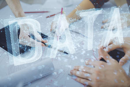 Double exposure of data theme hologram drawing and man and woman working together holding and using a mobile device.の写真素材