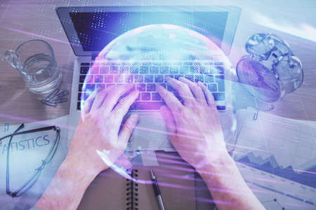 Double exposure of man's hands typing over computer keyboard and tech theme hologram drawing. Top...