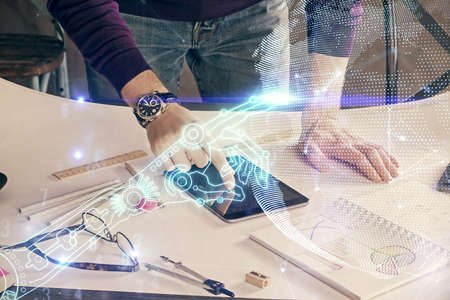 Double exposure of man's hands holding and using a digital device and tech theme hologram drawing....
