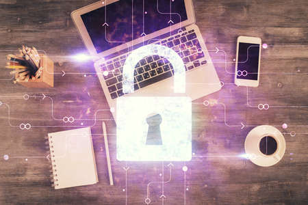 Double exposure of lock hologram drawing over study table background with computer. Concept of data...