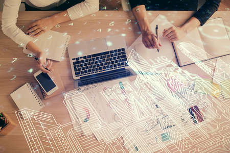 Double exposure of woman hands working on computer and buildings construction hologram drawing. Top View. smart city concept.の写真素材