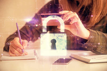 Double exposure of woman on-line shopping holding a credit card and Lock hologram drawing. Security...