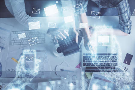 Double exposure of man and woman working together and the envelop hologram drawing. Computer...