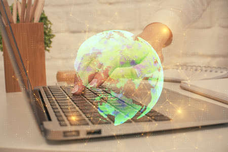 Double exposure of woman hands typing on computer and social network theme hologram drawing. People...