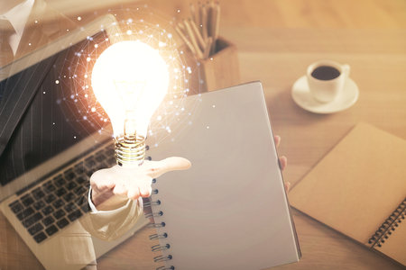 Double exposure of woman hands typing on computer and light bulb drawing. Idea concept.の写真素材