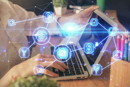 Double exposure of woman hands typing on computer and social network theme hologram drawing. People...