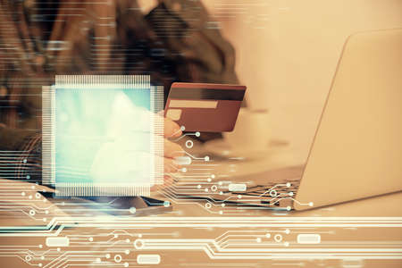 Double exposure of woman on-line shopping holding a credit card and data theme hologram drawing....