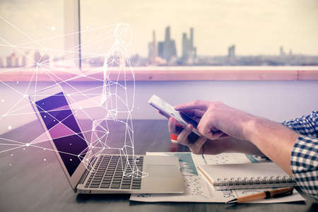 Double exposure of man's hands holding and using a mobile device and creative hologram drawing.