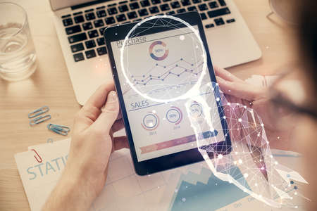 Double exposure of man's hands holding and using a mobile device and creative hologram drawing.