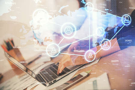 Double exposure of woman hands typing on computer and social network theme hologram drawing. People...