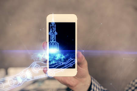 Double exposure of man's hands holding and using a mobile device and creative hologram drawing.の写真素材