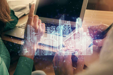 Double exposure of man and woman working together and buildings hologram drawing. Smart-city...